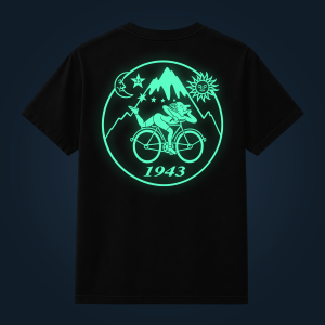 Neon mint graphic on black tee featuring a cyclist inside a circle with mountains, sun, moon, stars, and the year 1943 (back view).