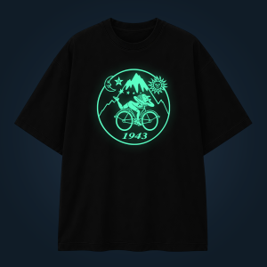Black hoodie with a glowing mint-green circular design featuring a cyclist, mountains, sun, and stars; 1943 at the bottom