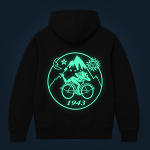 Back of a black hoodie featuring a large neon teal circular graphic with mountains, sun and the year 1943 on it (glow effect).
